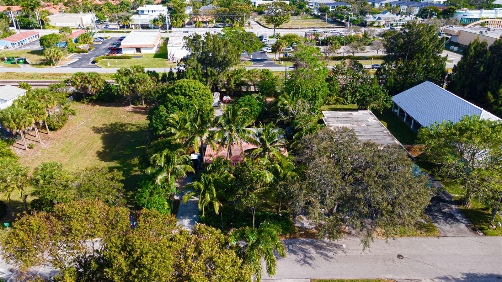 An aerial view shows a house surrounded by palm trees and a large adjacent lot — 1501 NE 3rd Avenue, Delray Beach FL 33444, DELRAY BEACH, FL