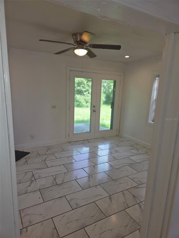 A room with white marble-look tile flooring, a ceiling fan, and glass double doors — 1243 AMAROS AVENUE, ORLANDO, FL