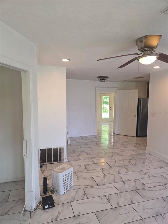 A room with white marble-look tile flooring, a ceiling fan, and a doorway leading outside — 1243 AMAROS AVENUE, ORLANDO, FL