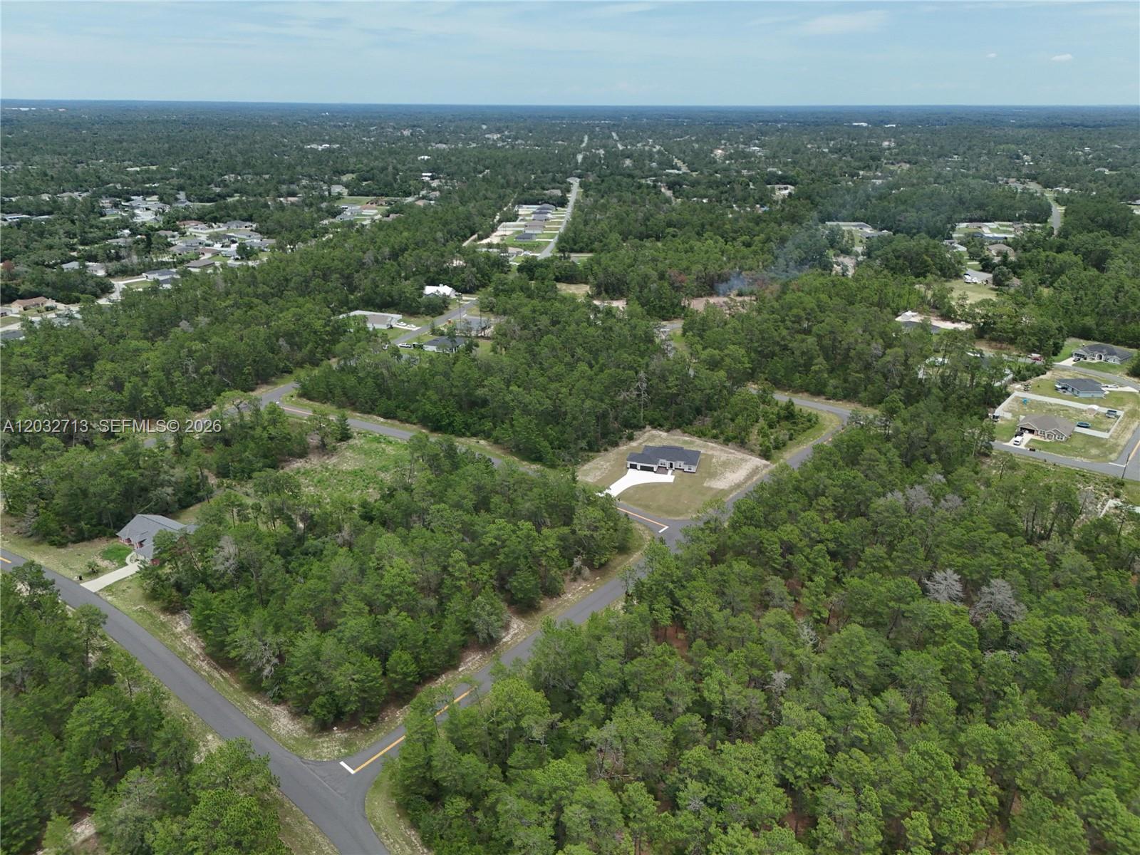 An aerial view shows a single-family home surrounded by dense forest and paved roads — 0 SW 40th Ct, Ocala FL 34473, OCALA, FL