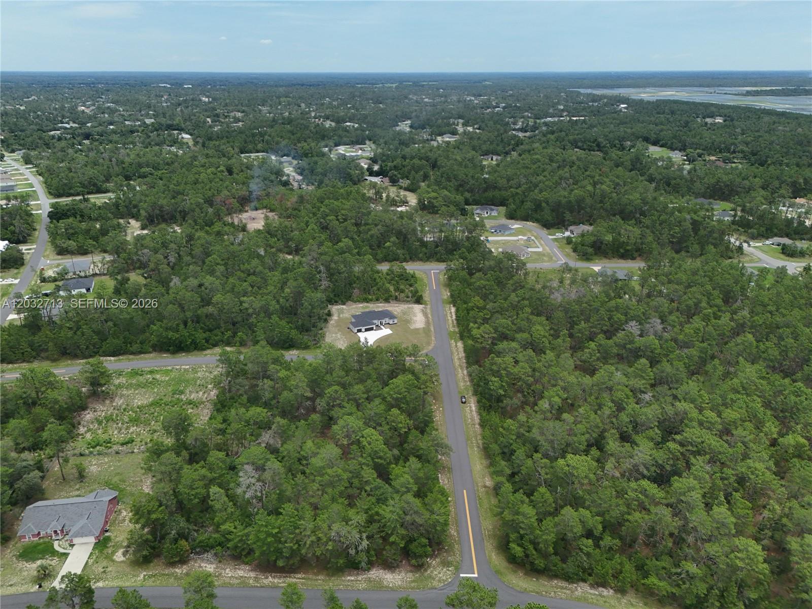 An aerial view shows a single-family home situated on a wooded lot near a road — 0 SW 40th Ct, Ocala FL 34473, OCALA, FL