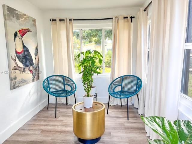 A sunlit room features two blue chairs, a central gold table, and a toucan painting — 1025 NW 55th St, Miami FL 33127, MIAMI, FL
