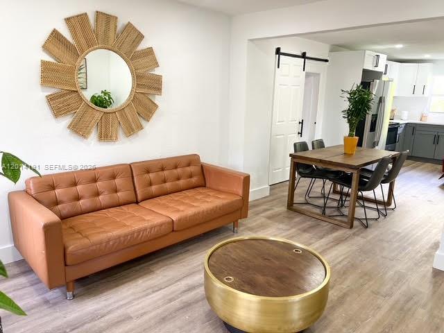 A living room features a brown leather sofa, a gold coffee table, and a dining area — 1025 NW 55th St, Miami FL 33127, MIAMI, FL