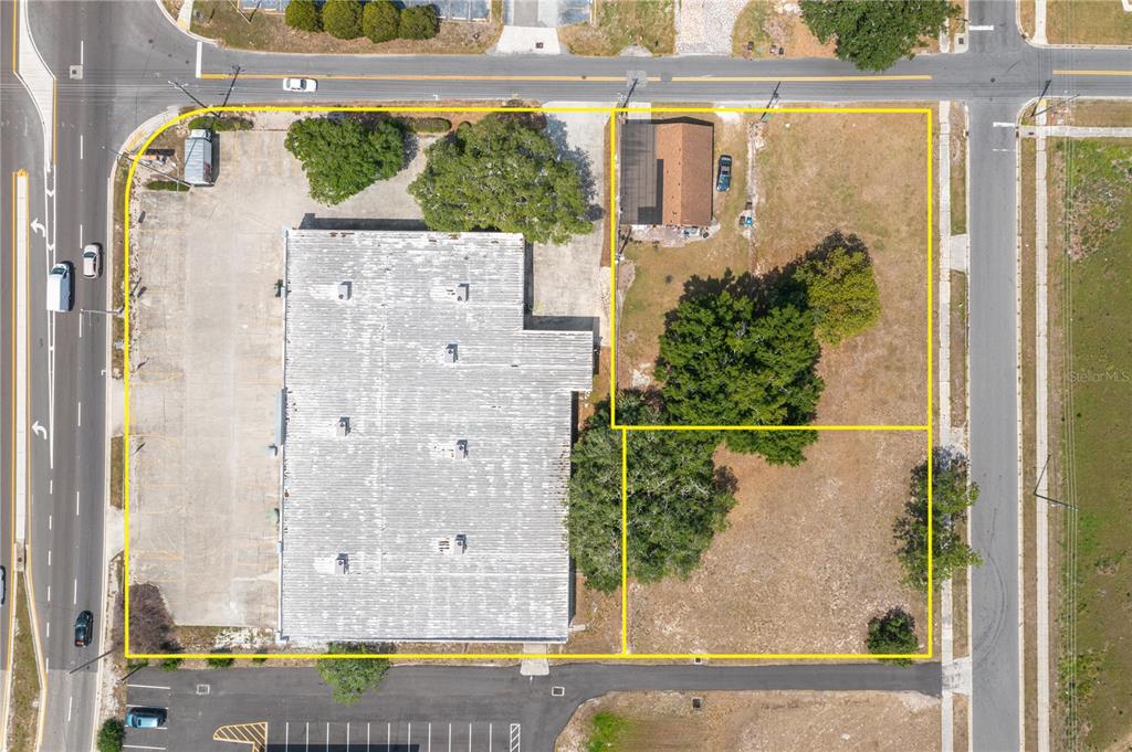 This aerial view shows a commercial building with a parking lot and two adjacent lots — 126 STATE ROAD 60 W, LAKE WALES, FL
