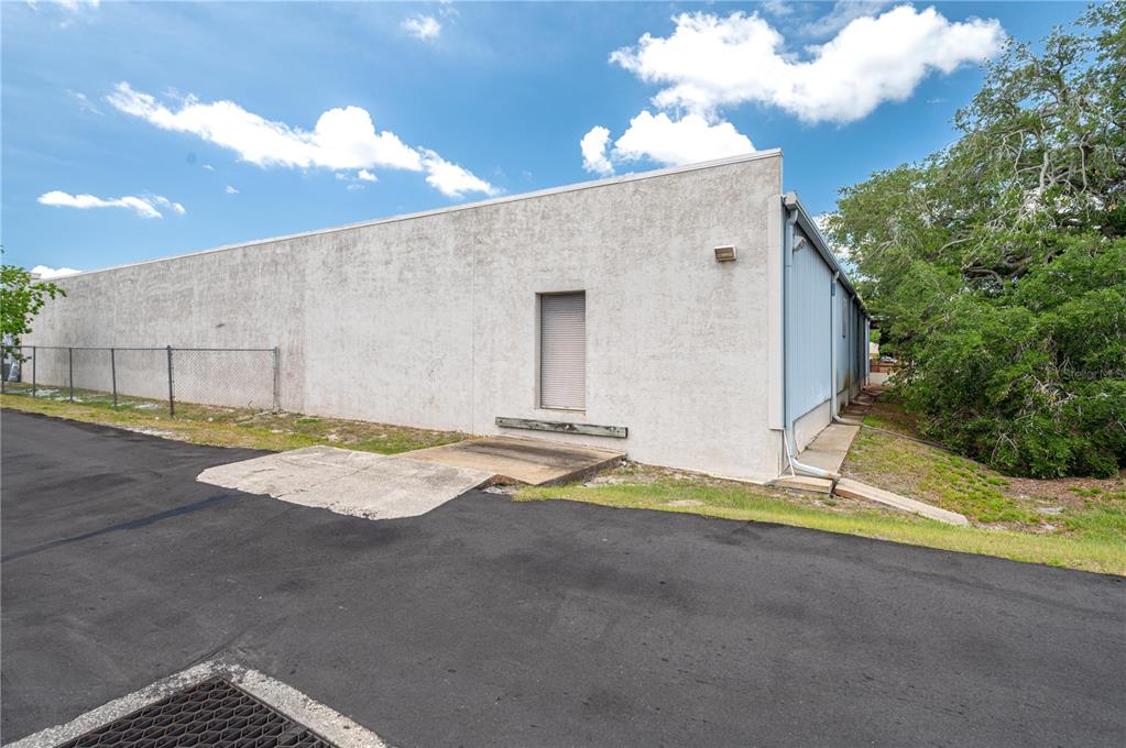 The exterior of a commercial building features a concrete wall, a loading dock, and asphalt — 126 STATE ROAD 60 W, LAKE WALES, FL