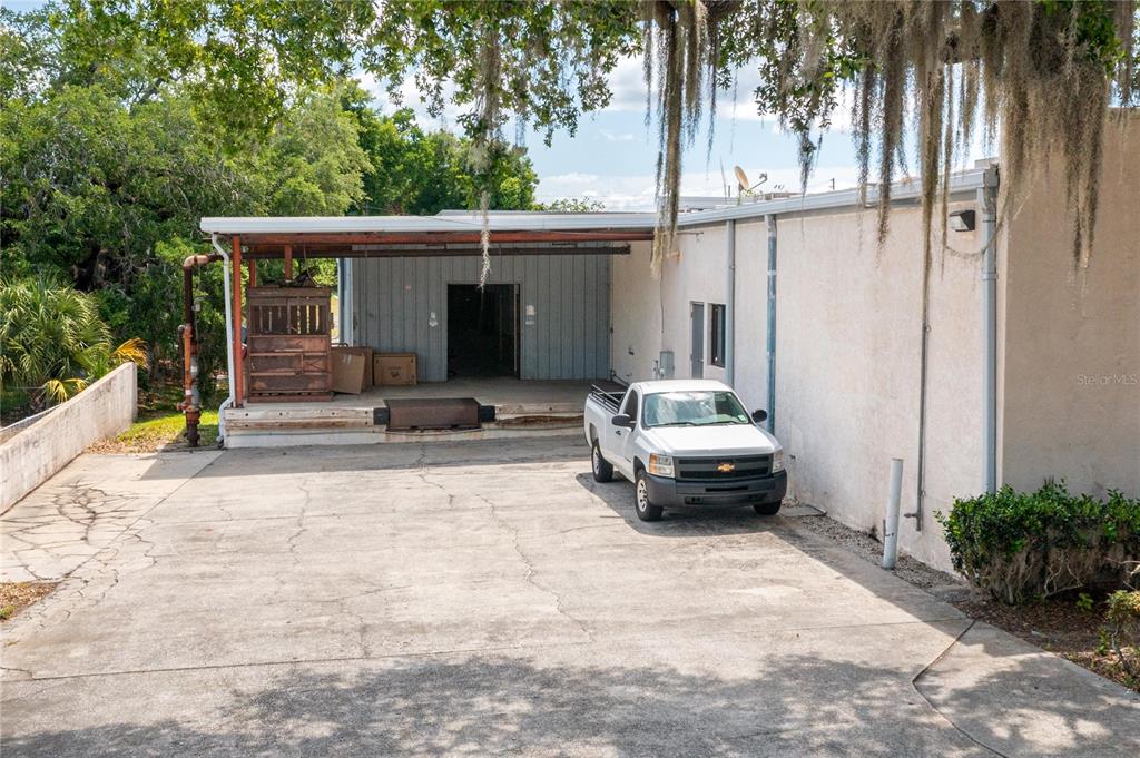 A white pickup truck is parked in front of a warehouse loading dock — 126 STATE ROAD 60 W, LAKE WALES, FL