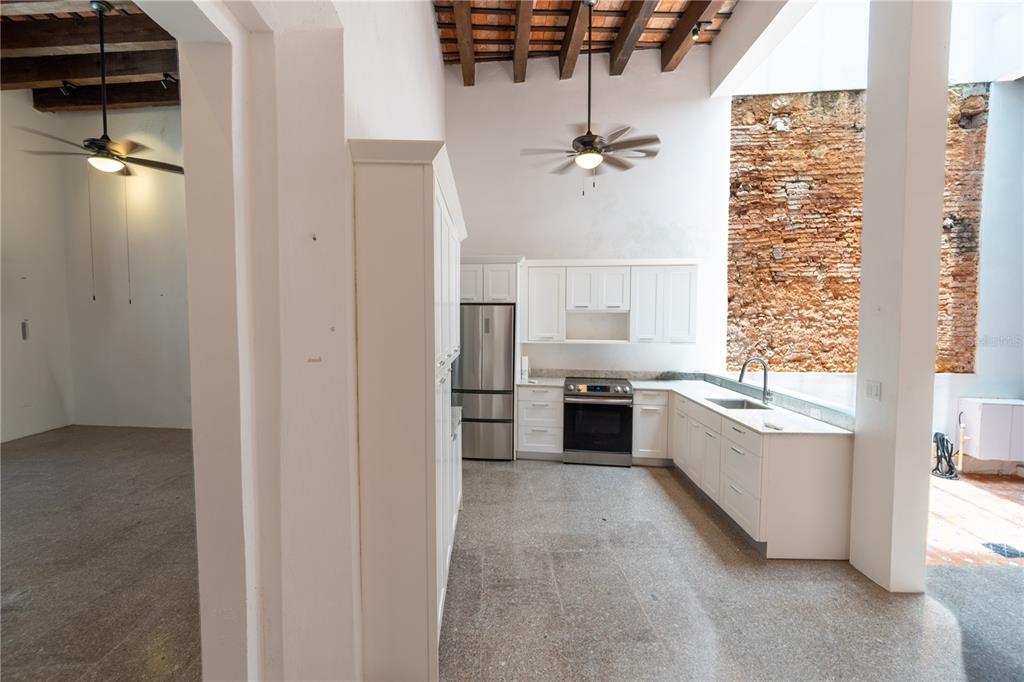 A living and dining area features exposed wood ceiling beams, brick arches, and tile floors — 8 DE LA CRUZ, SAN JUAN, PR