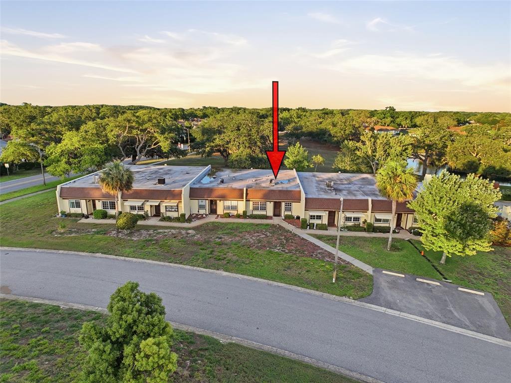 An aerial view shows a single-story multi-unit residential building with a flat roof — 11430 CARRIAGE HILL DRIVE UNIT 4, PORT RICHEY, FL