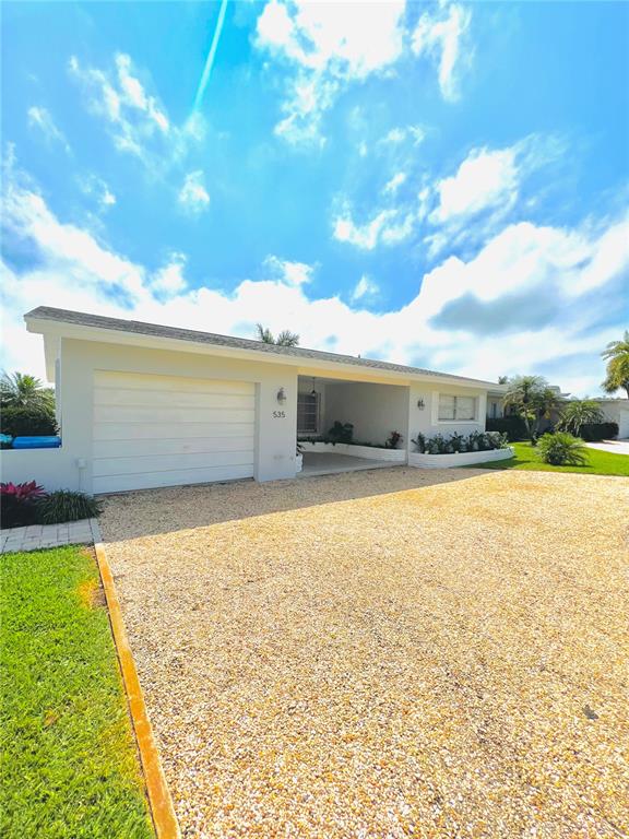 A single-story house with a white exterior, a garage, and a gravel driveway — 535 173RD AVENUE, NORTH REDINGTON BEACH, FL