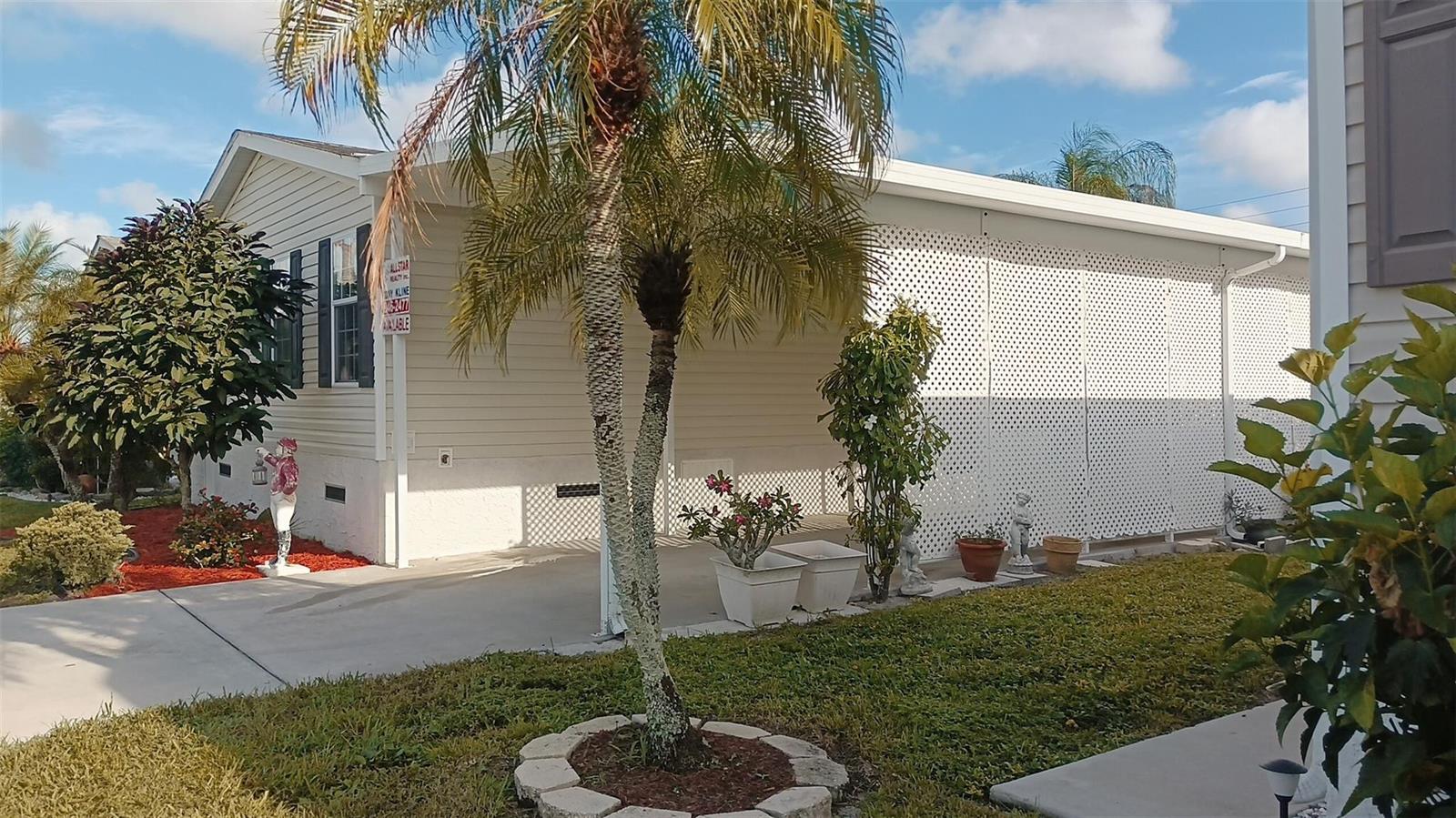 A light-colored mobile home features a palm tree, a carport, and white lattice siding — 8204 South Street, Boca Raton FL 33433, BOCA RATON, FL