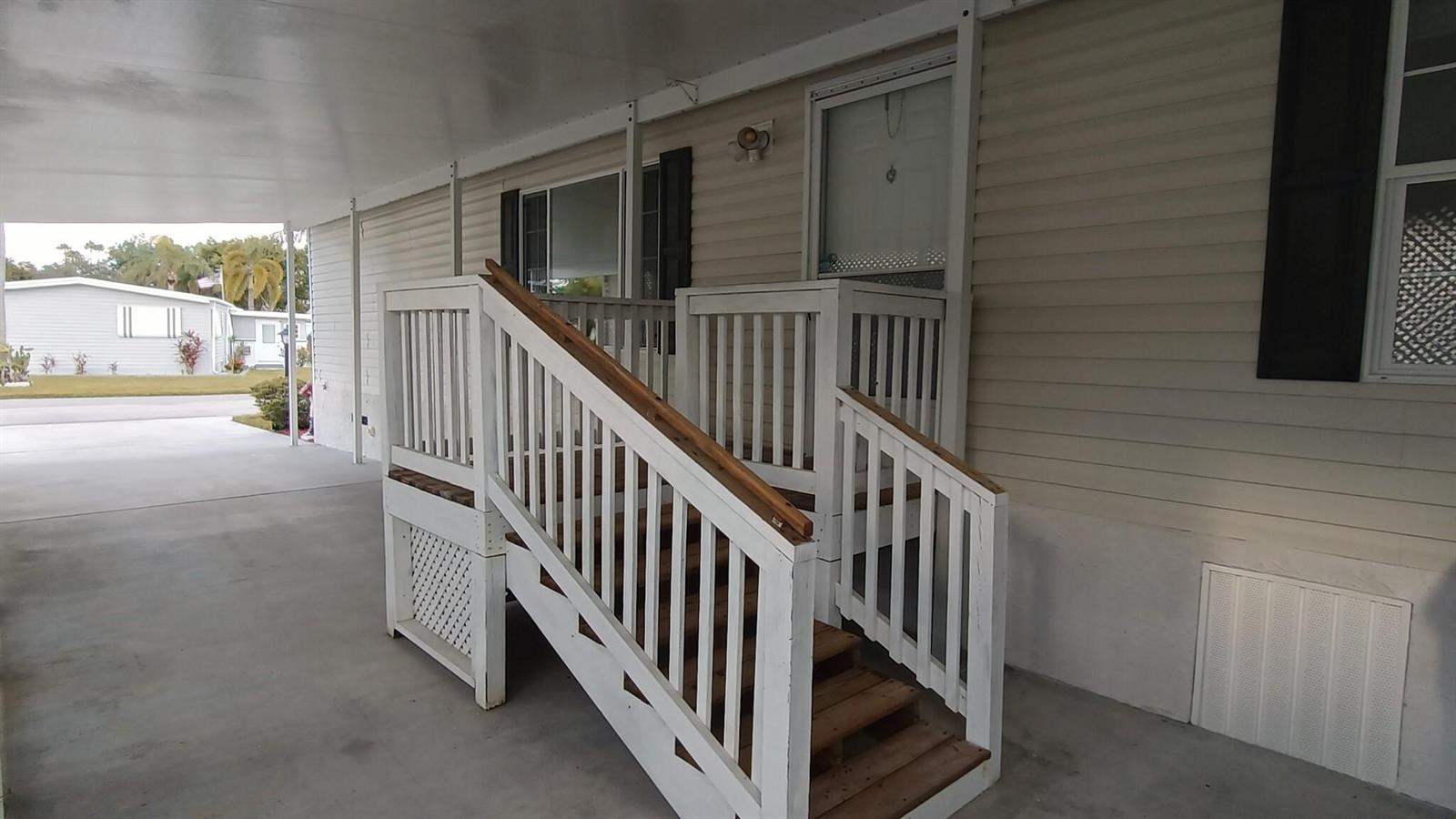 A white wooden staircase with railings leads to the entrance of a mobile home — 8204 South Street, Boca Raton FL 33433, BOCA RATON, FL