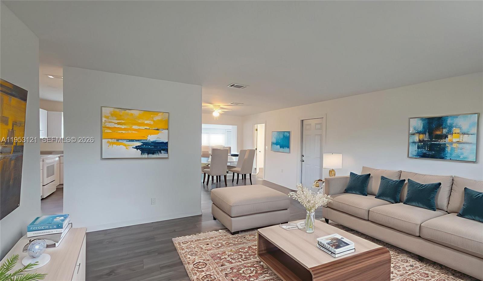 A living room features a beige sofa, a patterned rug, and abstract wall art — 4008 Rye Ct, La Belle FL 33935, LA BELLE, FL