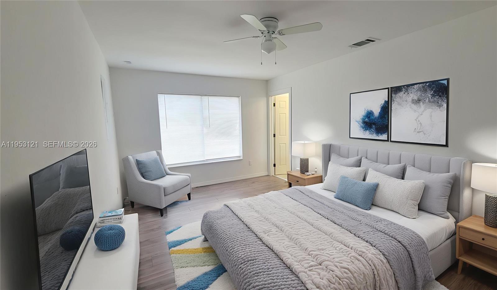 A modern bedroom features a gray upholstered bed, a matching armchair, and a ceiling fan — 4008 Rye Ct, La Belle FL 33935, LA BELLE, FL