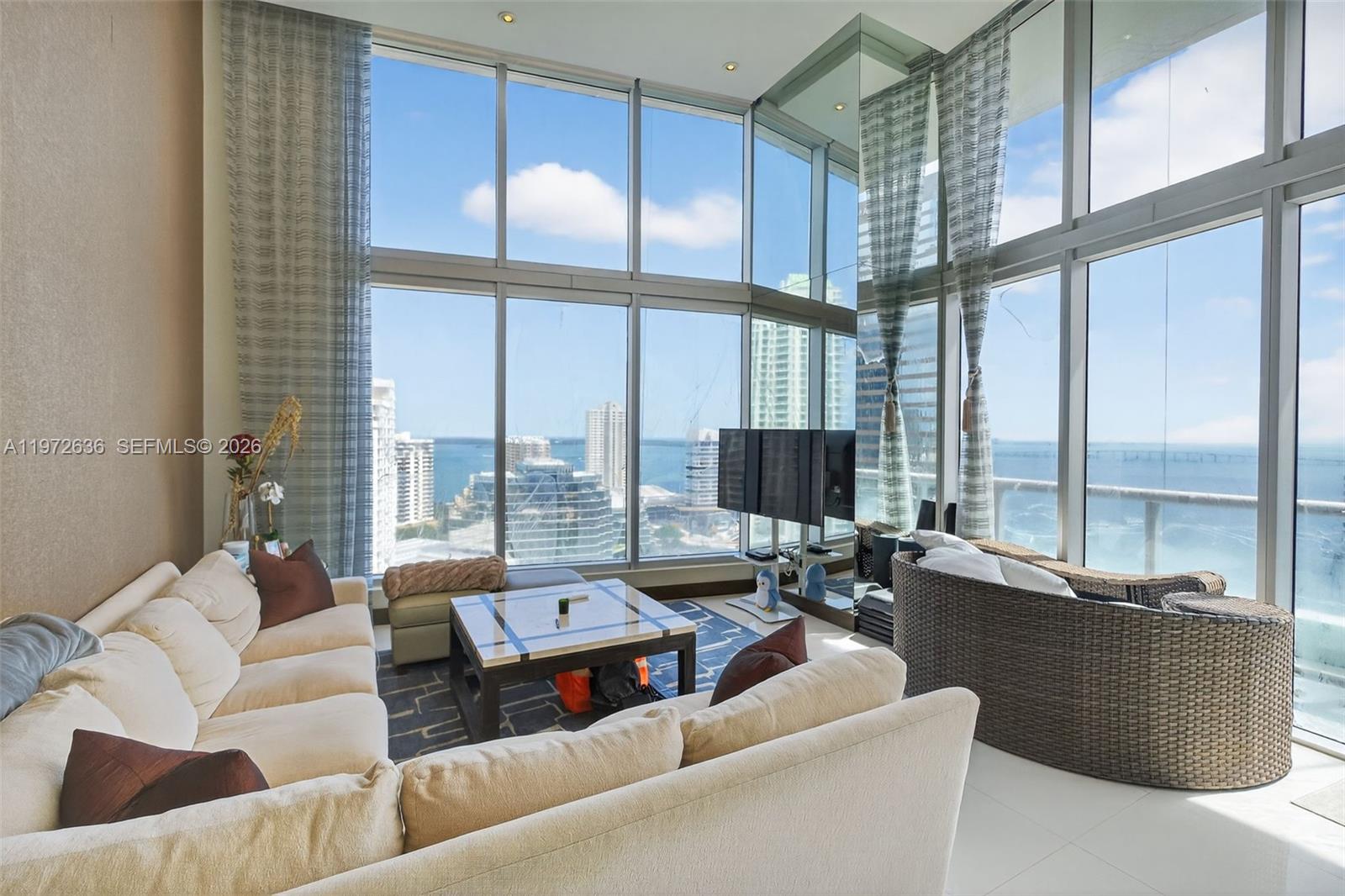 A living room features floor-to-ceiling windows with city and water views and a sectional sofa — 495 Brickell avenue # 2201, Miami FL 33131, MIAMI, FL