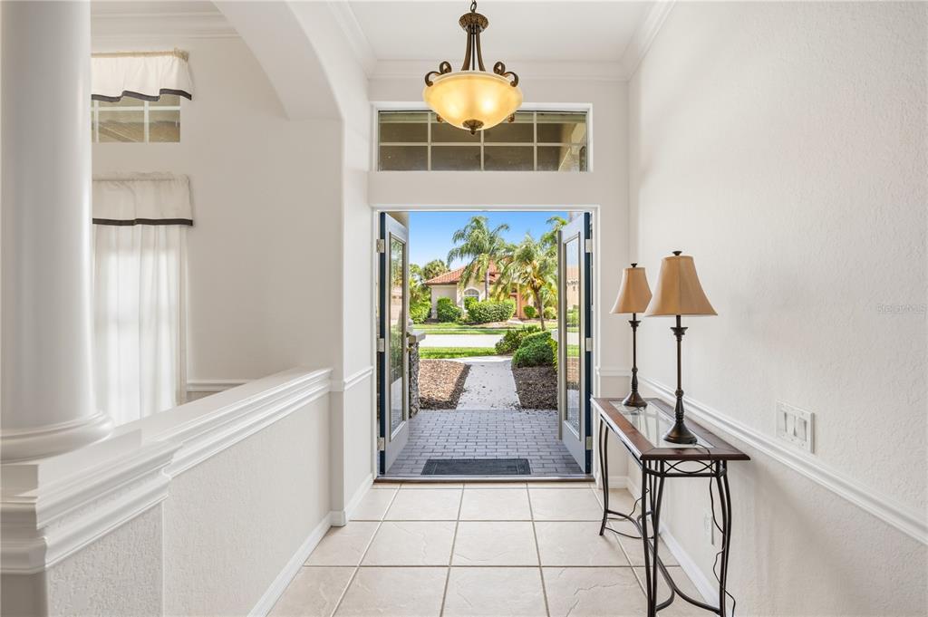 A bright entryway with tile floors, a console table, and a view of the outdoors — 5291 WHITE IBIS DRIVE, NORTH PORT, FL