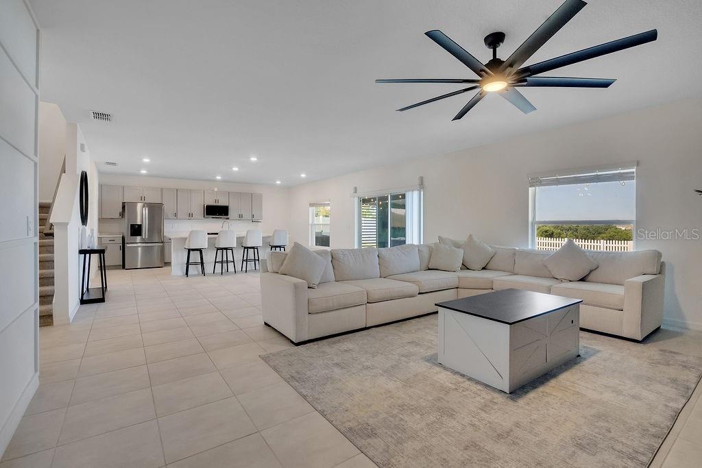 A living room features a white sectional sofa, a black fireplace wall, and sliding glass doors — 1033 CALICO POINTE CIRCLE, GROVELAND, FL
