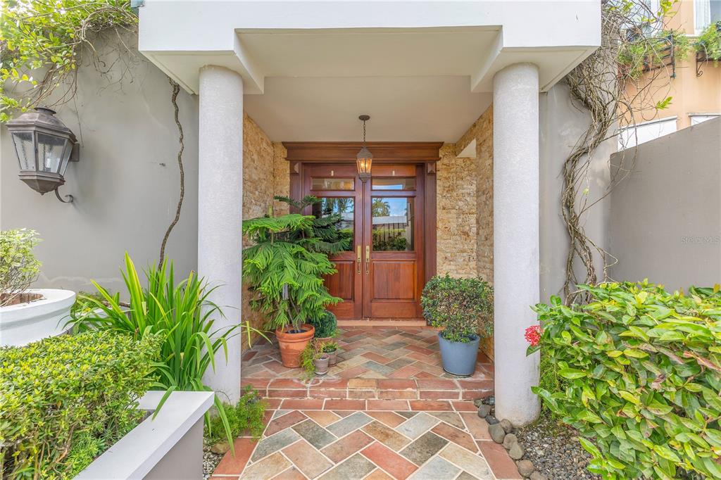 A covered entryway features a double wooden door, stone walls, and a herringbone brick floor — A2 MONTEBELLO STREET, GUAYNABO, PR