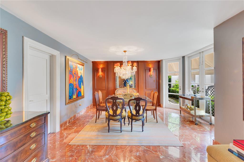 A formal dining room features wood-paneled walls, a crystal chandelier, and polished red marble floors — A2 MONTEBELLO STREET, GUAYNABO, PR