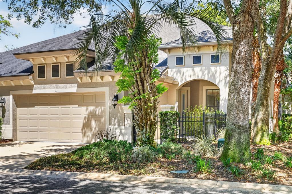 A single-story house with a beige garage, arched entryway, and palm tree in the front yard — 6 RIVER POINT DRIVE, PALM COAST, FL