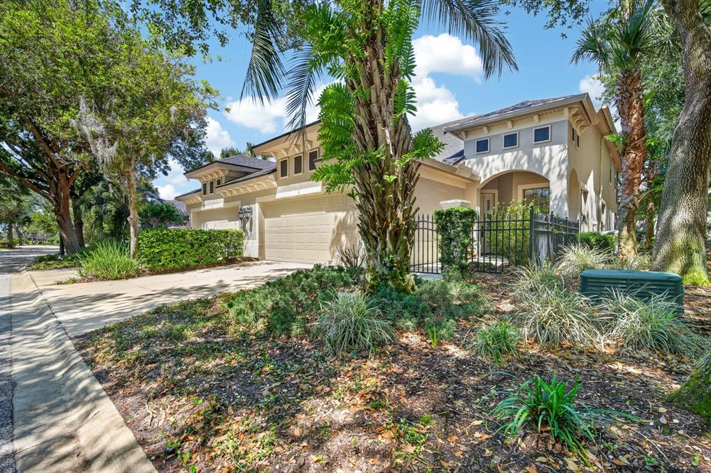 A two-story house with a beige stucco exterior, a two-car garage, and a gated entrance — 6 RIVER POINT DRIVE, PALM COAST, FL
