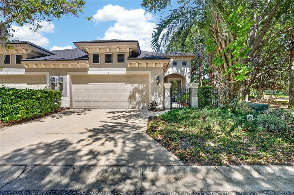 A beige single-story house exterior features a two-car garage, a gated entryway, and landscaping — 6 RIVER POINT DRIVE, PALM COAST, FL
