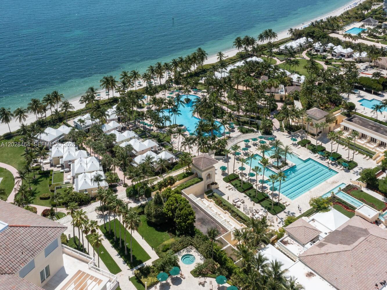 An aerial view of a coastal resort featuring multiple swimming pools and white villas — 781 Crandon Blvd # 405, Key Biscayne FL 33149, KEY BISCAYNE, FL