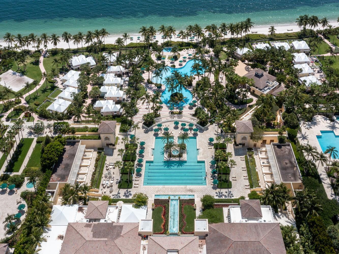 An aerial view shows a luxury resort with multiple swimming pools and beach access — 781 Crandon Blvd # 405, Key Biscayne FL 33149, KEY BISCAYNE, FL