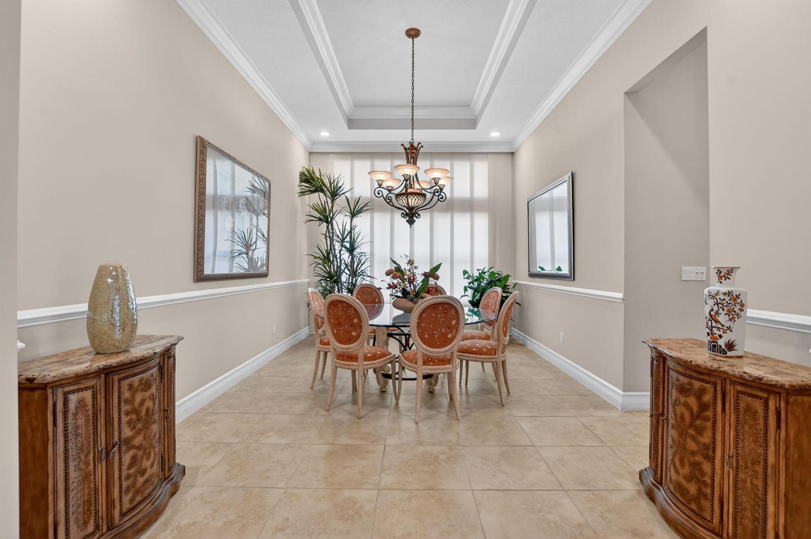 A formal dining room features a glass table, six chairs, a chandelier, and two cabinets — 12133 Glacier Bay Drive, Boynton Beach FL 33473, BOYNTON BEACH, FL