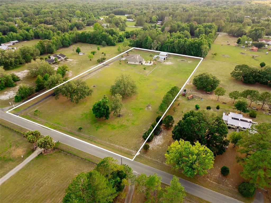 An aerial view shows a house and outbuilding on a large, fenced rural lot — 6739 SE 67TH COURT, TRENTON, FL