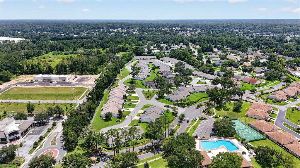 An aerial view shows a residential community with townhomes, a swimming pool, and a tennis court — 2429 SE 18TH CIRCLE, OCALA, FL