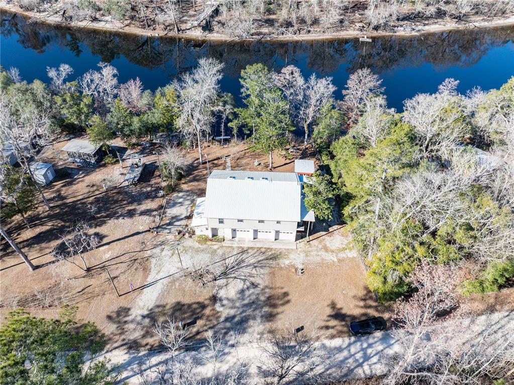 An aerial view shows a two-story house with a metal roof near a river — 30009 81ST PLACE, BRANFORD, FL