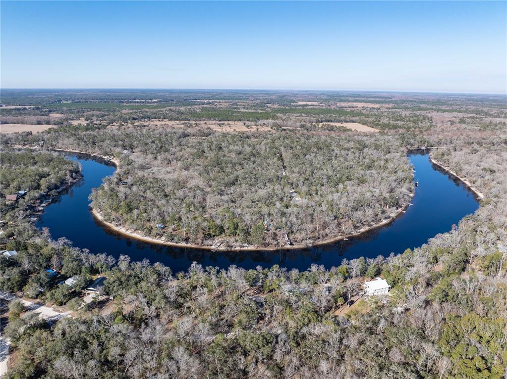 An aerial view shows a river forming a large horseshoe bend surrounded by dense forest — 30009 81ST PLACE, BRANFORD, FL