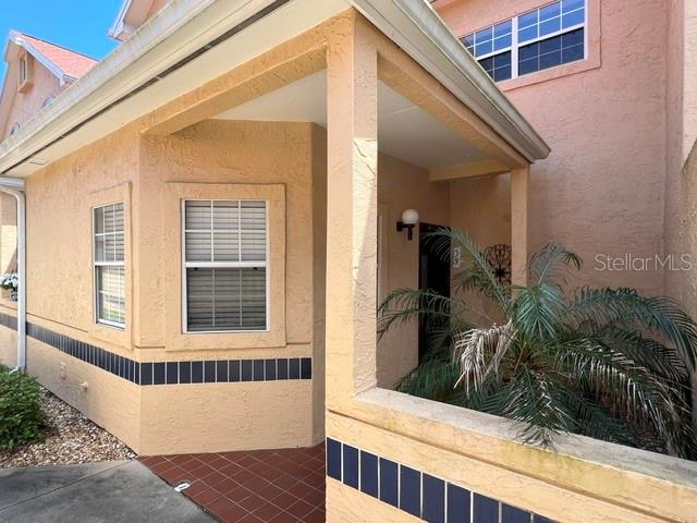 Exterior view of a tan stucco building with a covered entryway and tiled porch — 35 CAPTAINS WALK, PALM COAST, FL