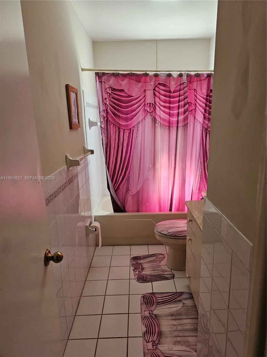 A bathroom features a white tiled floor, a toilet, a vanity, and a shower-tub combination — 9905 Marlin RD, Cutler Bay FL 33157, CUTLER BAY, FL