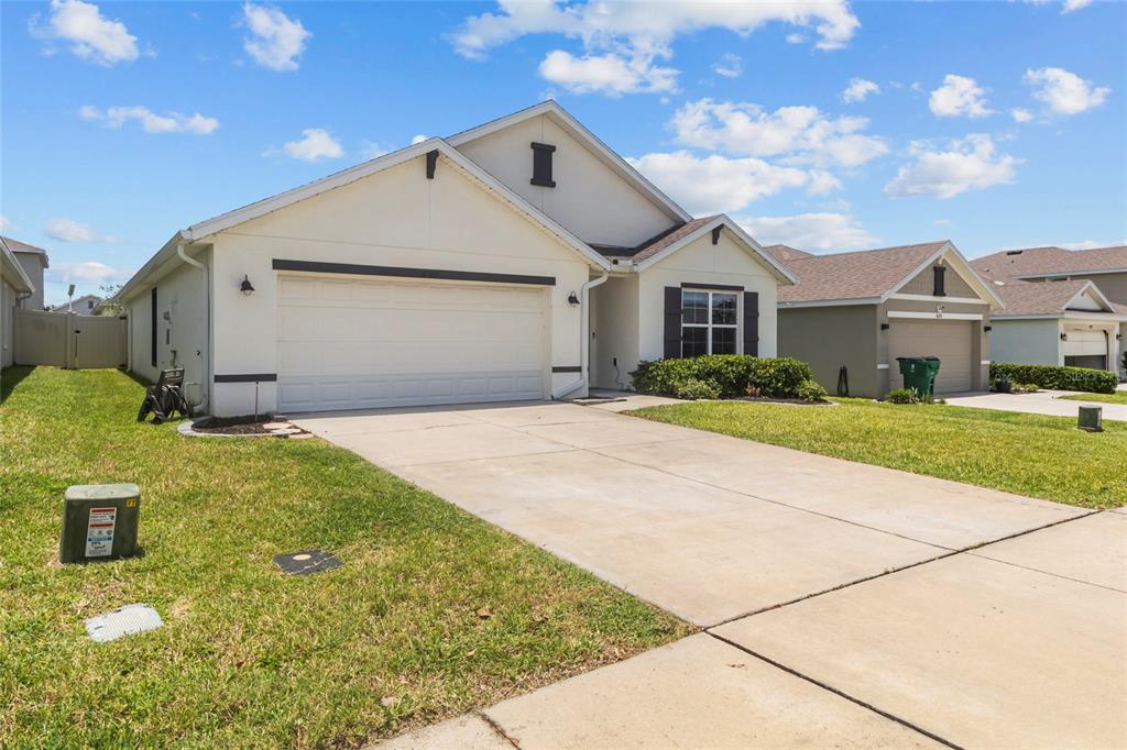 A single-story suburban house with a two-car garage and a concrete driveway — 38386 SONNET LANDING AVENUE, ZEPHYRHILLS, FL