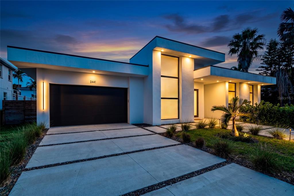 A modern, white single-story house with a flat roof, large windows, and a concrete driveway — 2441 WEBBER STREET, SARASOTA, FL
