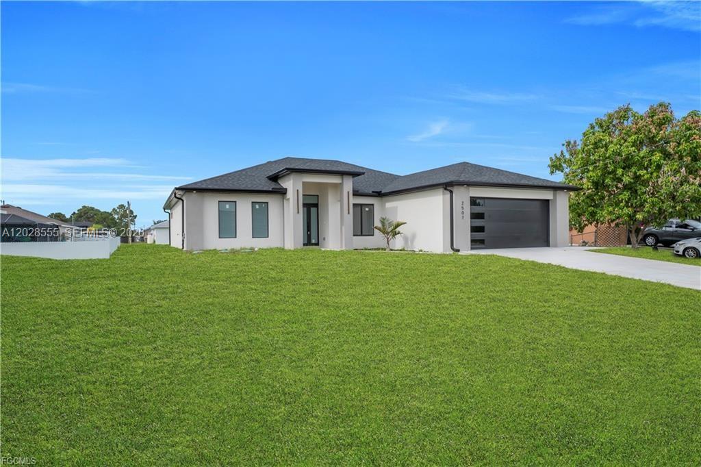 A modern single-story house with a white exterior, dark roof, and a two-car garage — 2507 39th ST SW, Lehigh Acres FL 33976, LEHIGH ACRES, FL