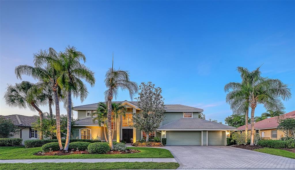 A two-story house with a paved driveway, palm trees, and a three-car garage — 4839 SWEETMEADOW CIRCLE, SARASOTA, FL