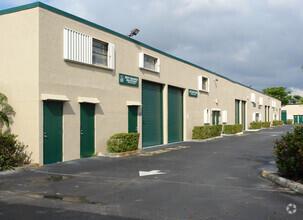 A low-rise commercial building with green doors and roll-up bays along a paved parking lot — 1791 Blount Road # 814, Pompano Beach FL 33069, POMPANO BEACH, FL