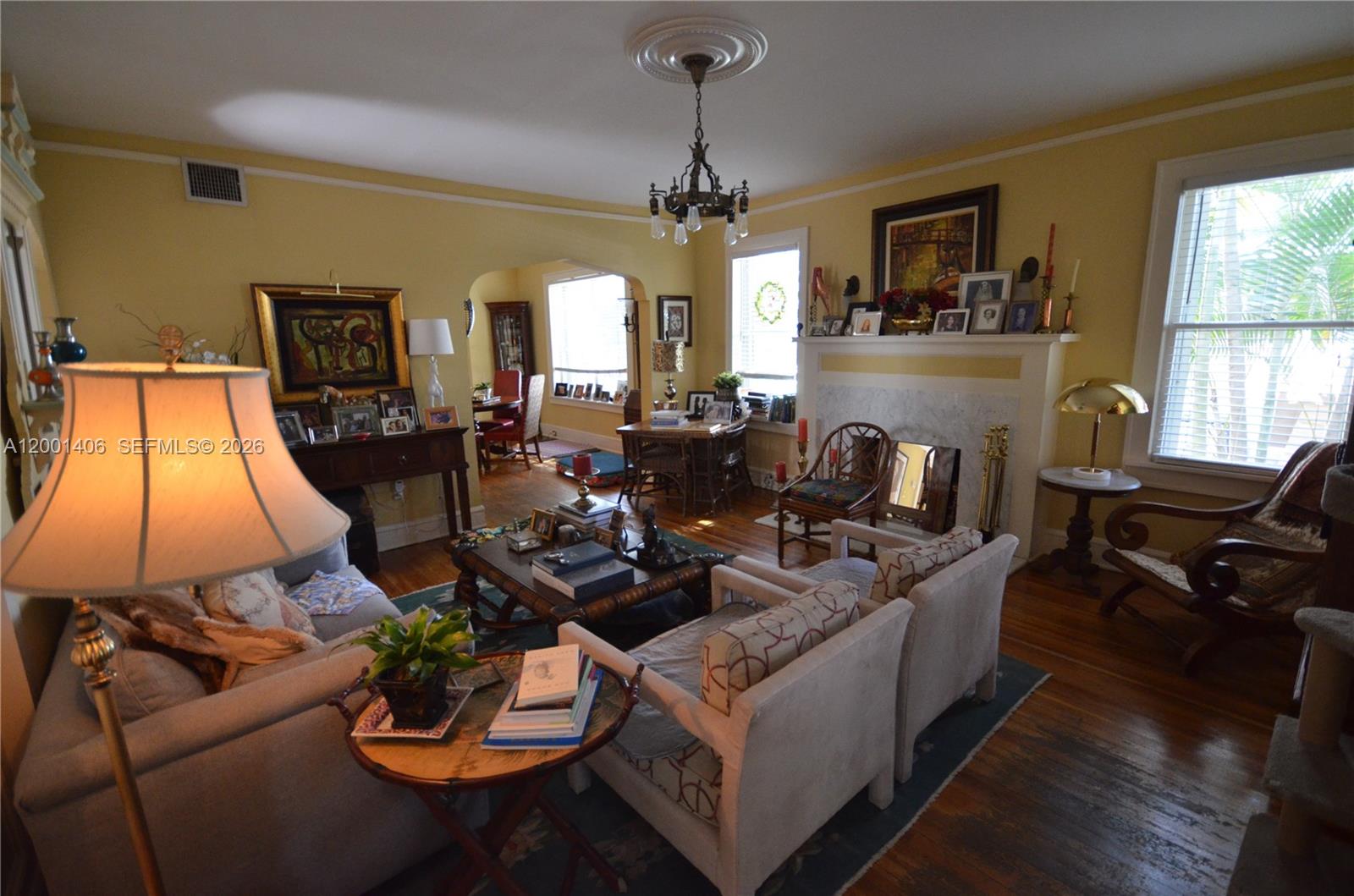 A living room with yellow walls, a fireplace, hardwood floors, and traditional furniture — 334 NE 26th Ter, Miami FL 33137, MIAMI, FL