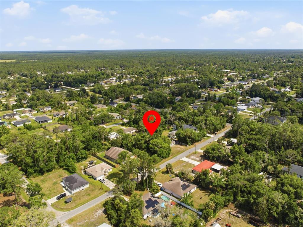 An aerial view shows a wooded residential lot marked by a red pin — 2155 5TH AVENUE, DELAND, FL