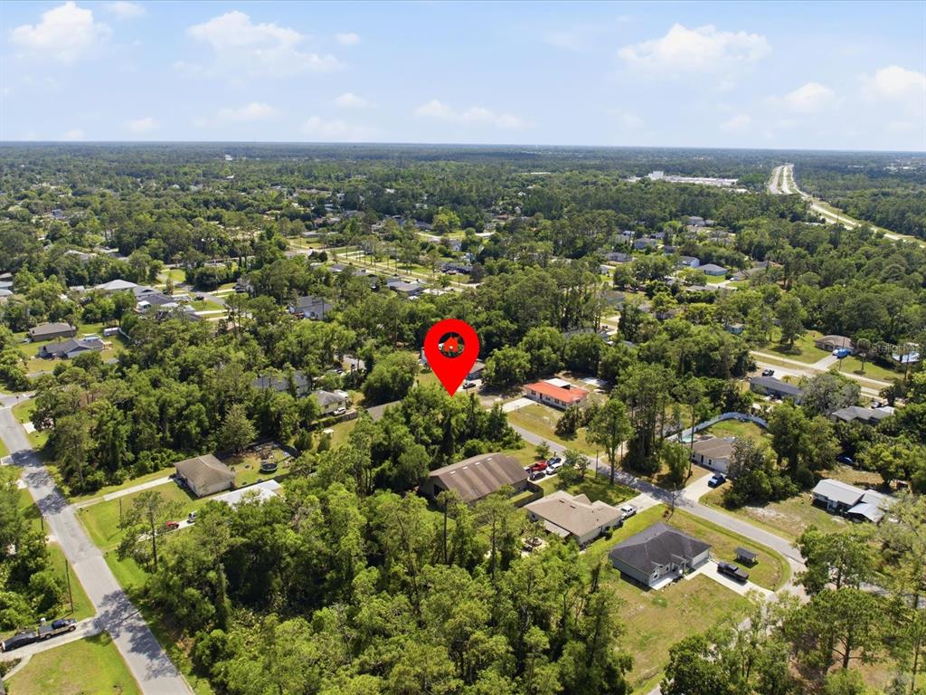 An aerial view shows a red location pin over a wooded residential lot — 2155 5TH AVENUE, DELAND, FL