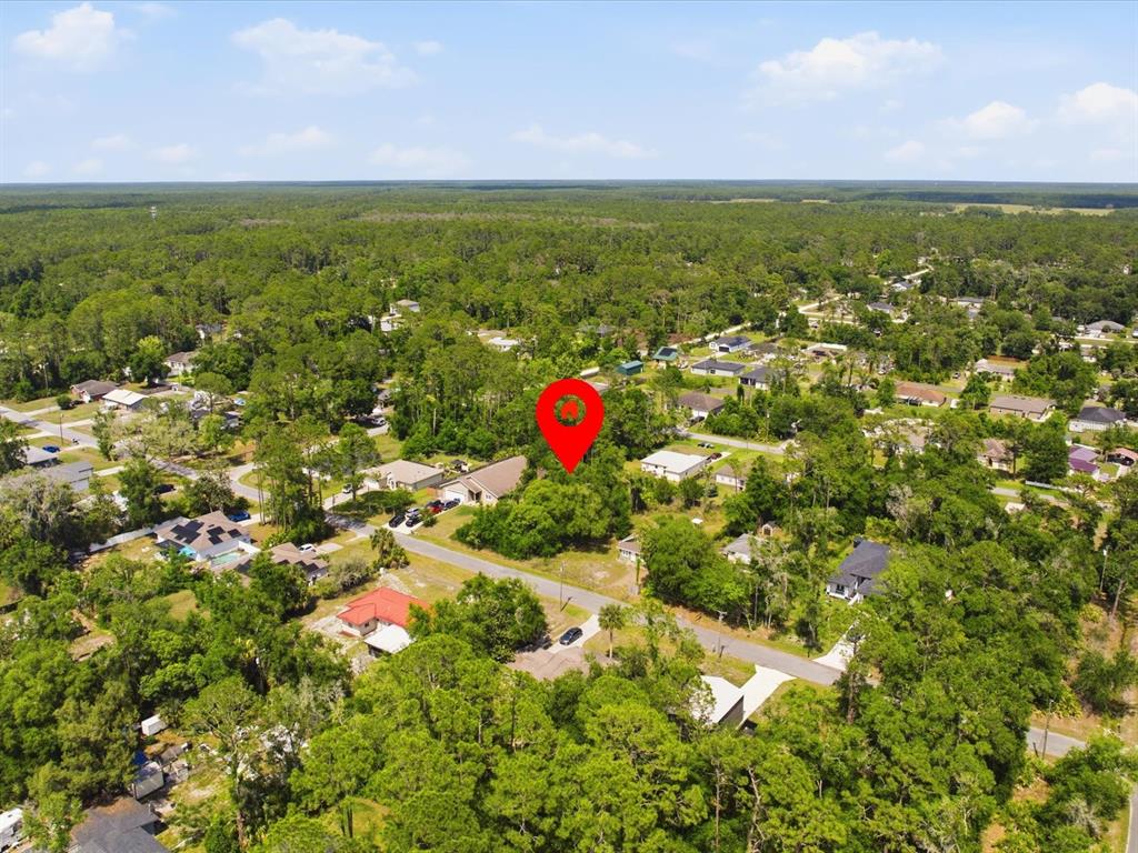 An aerial view shows a wooded residential lot marked by a red pin — 2155 5TH AVENUE, DELAND, FL