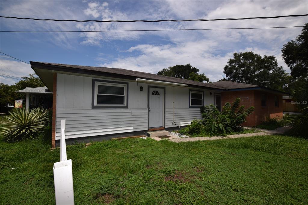 A single-story house with white horizontal siding, a brick section, and a front entrance — 305 W HANCOCK STREET, LAKELAND, FL
