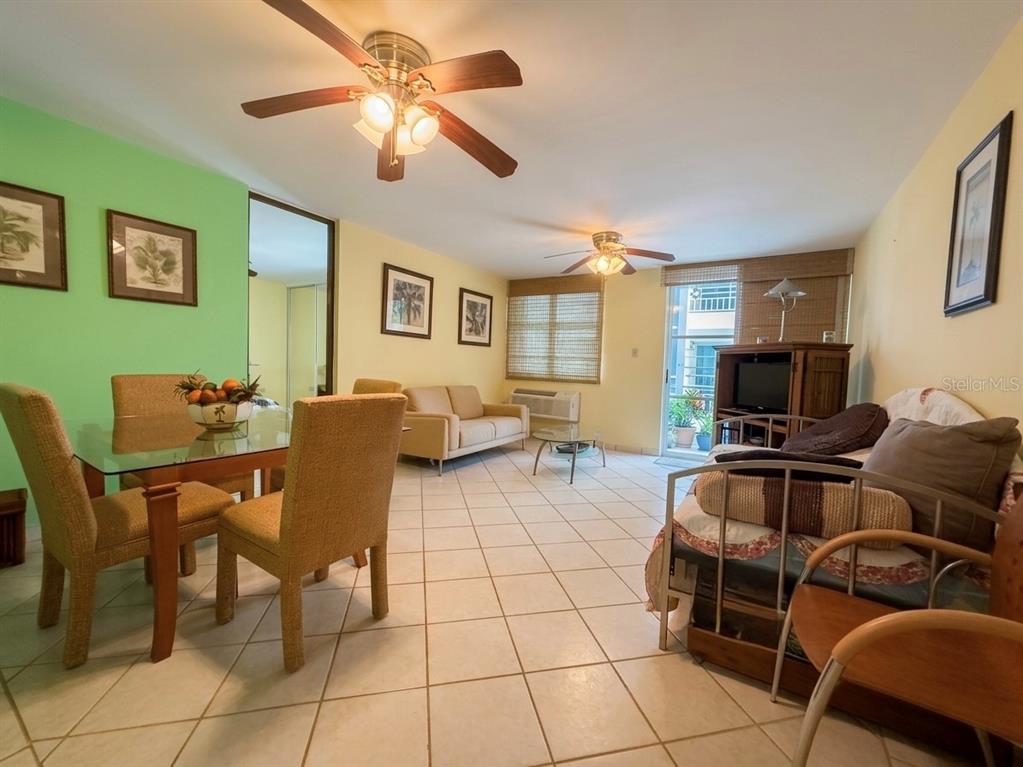 A living and dining area features tile floors, two ceiling fans, and a balcony door — 614 NE BEACHSIDE DRIVE UNIT 205, LUQUILLO, PR