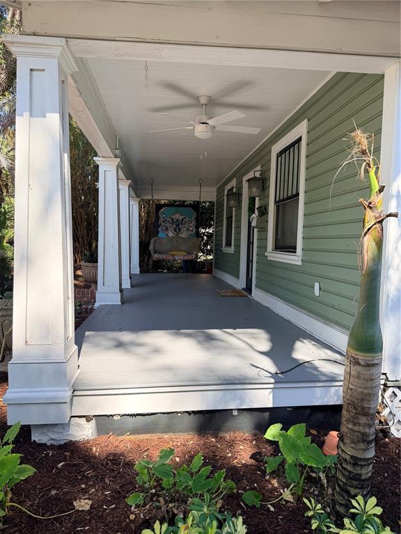 A covered front porch features a ceiling fan, a hanging swing, and green siding — 1004 PALMER STREET, ORLANDO, FL