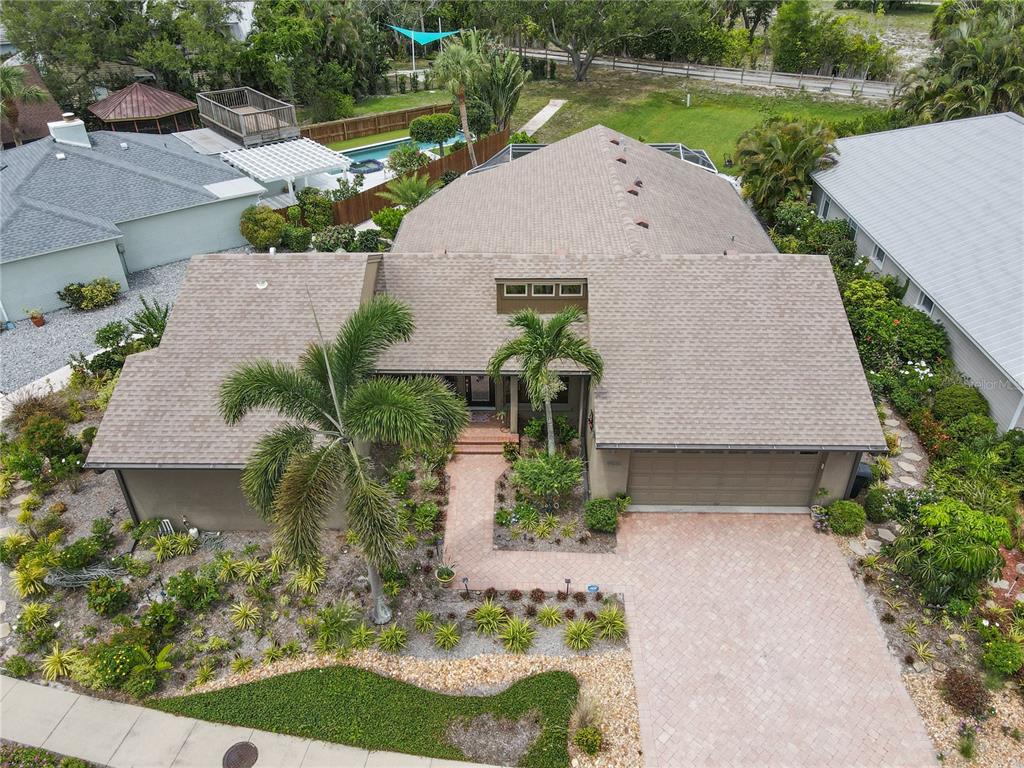 An aerial view of a single-story house with a paved driveway and landscaped front yard — 2408 89TH STREET NW, BRADENTON, FL