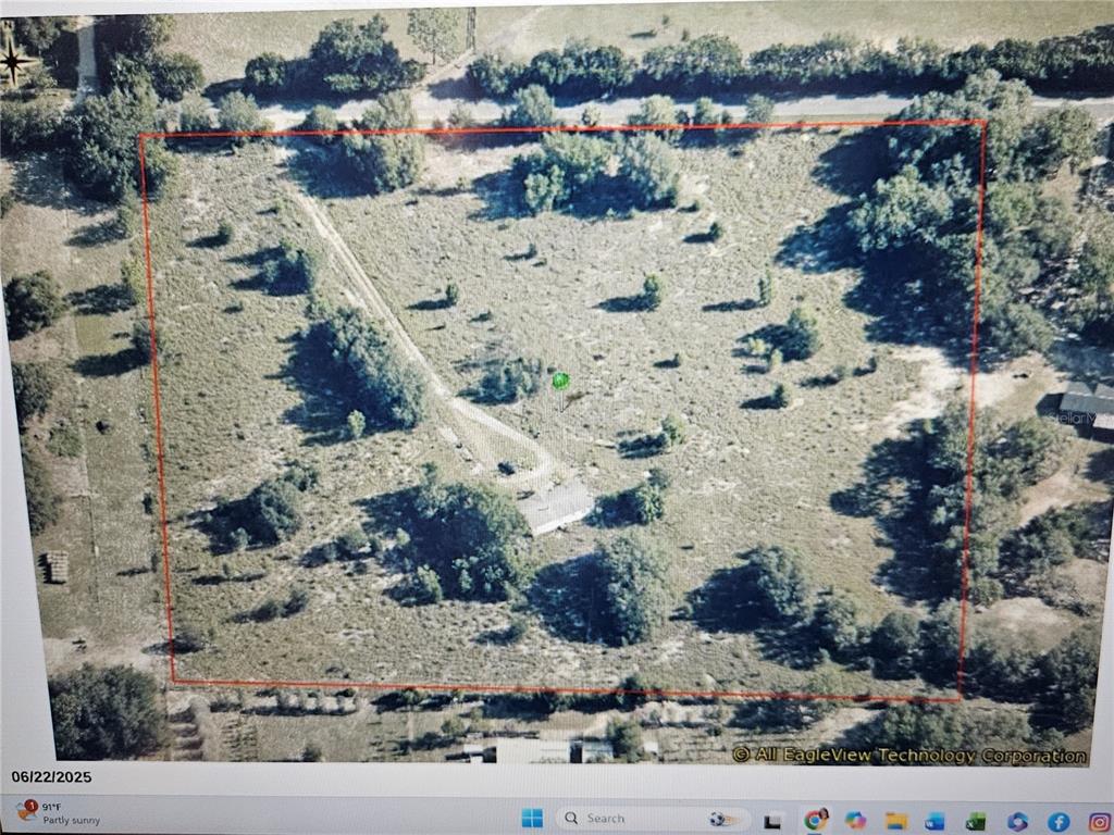 An aerial view of a rectangular plot of land featuring a driveway and a small building — 3814 W RANCETTA STREET, DUNNELLON, FL