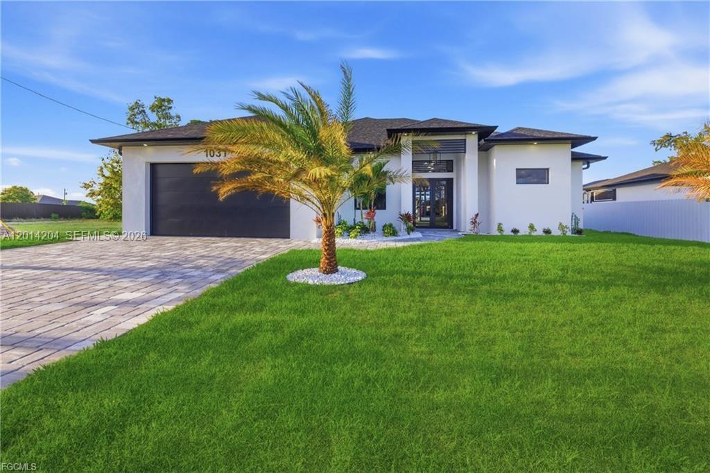 A modern single-story house with a white exterior, dark garage door, and a palm tree — 1031 SW 1st TER, Cape Coral FL 33991, CAPE CORAL, FL