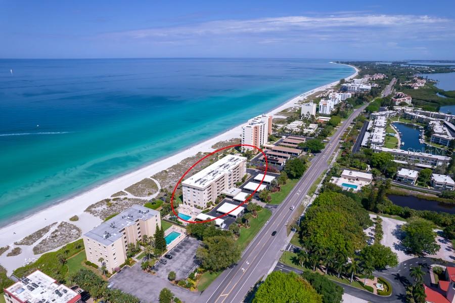 An aerial view shows a multi-story beachfront apartment building circled in red along the coast — 4325 GULF OF MEXICO DRIVE UNIT 507, LONGBOAT KEY, FL